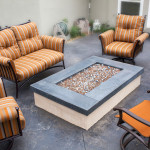 The patio area surrounding the fire pit is dark stained stamped concrete